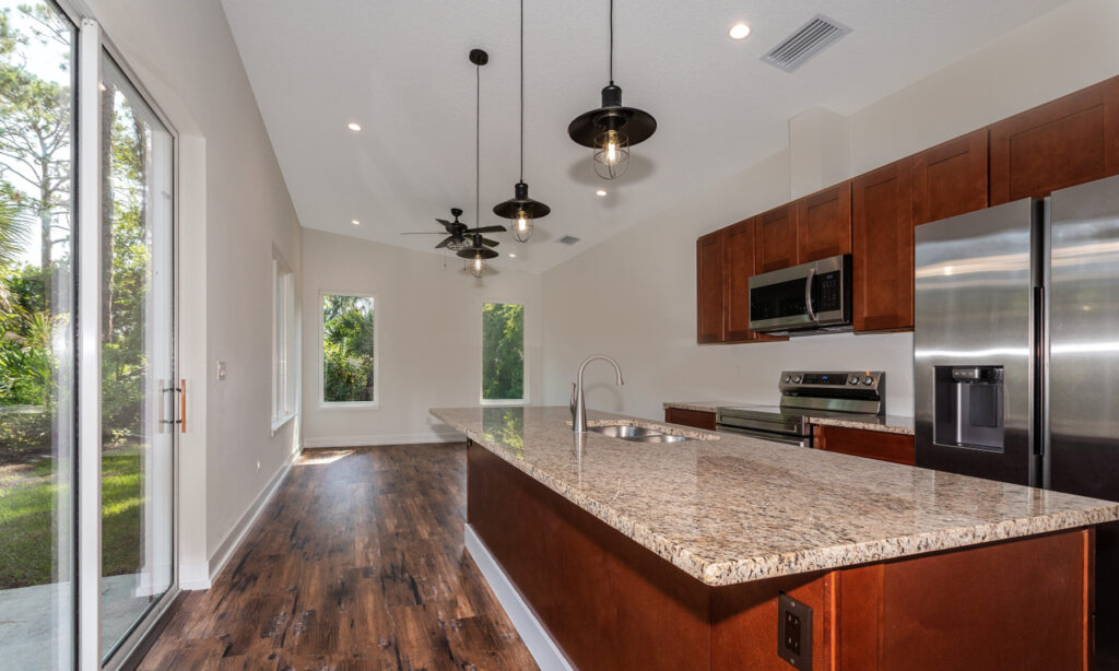 kit home kitchen with granite top island and hanging light pendants