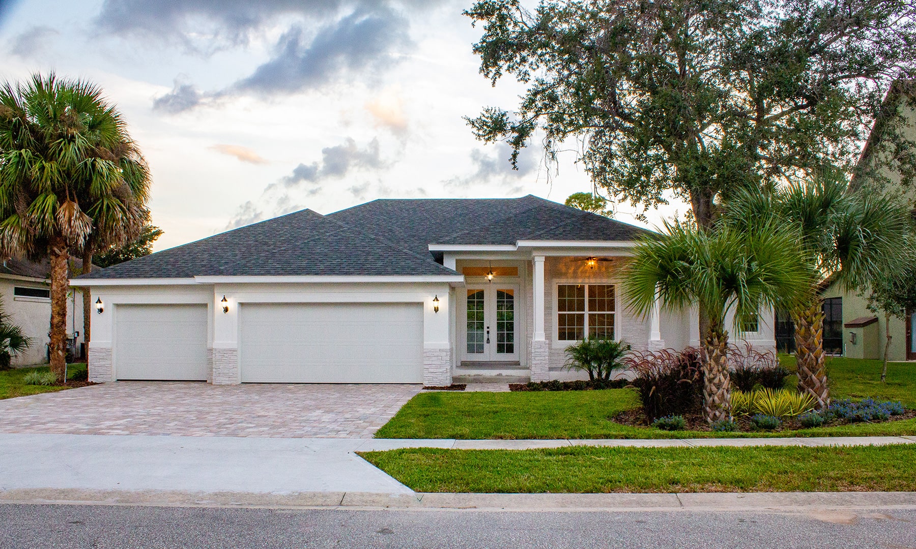 Spec house exterior, white with large trees in yard