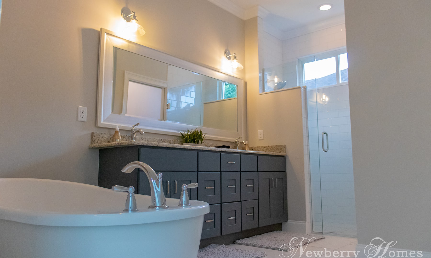 spec house bathroom with soaking tub and glass shower enclosure, and a double vanity with dark brown cabinet base